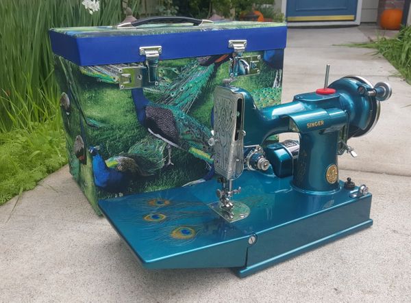 A blue sewing machine with peacock prints
