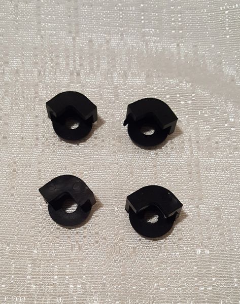 Four black sewing machine parts